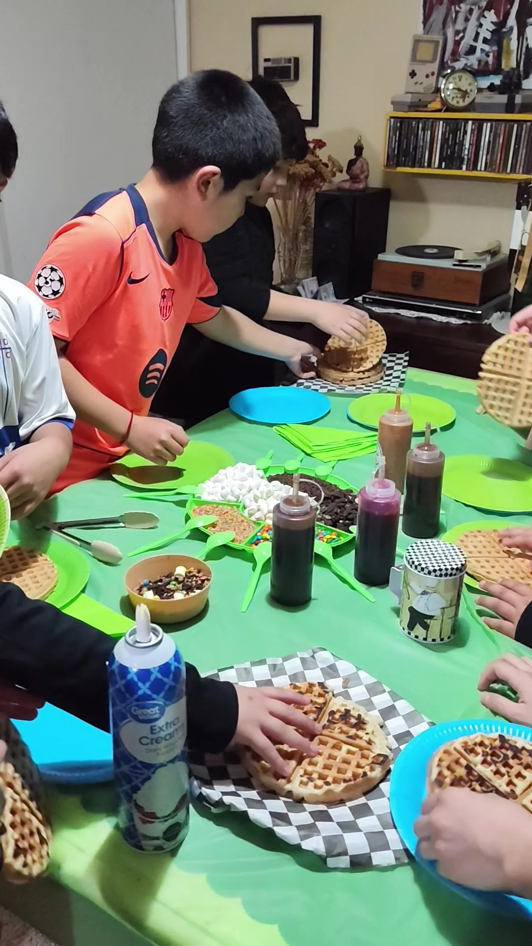 Invitados personalizando sus waffles en una mesa con toppings